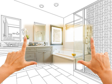 Hands frame a bathroom with half-drawn, half-real design. Features include a sink, mirror, tub, and shower, with warm lighting.