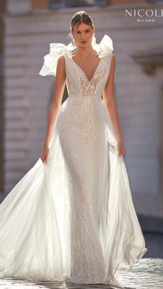 Sleeveless mermaid wedding dress with luminous paillettes. The tulle layer transforms this sensual dress into a romantic, sophisticated look for the ceremony.