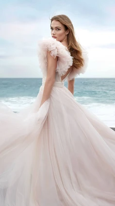 A-line wedding dress crafted wholly of antique rose tulle with sweetheart neckline and tulle draping. Tulle ruffle sleeves are detachable, dress also has tulle spaghetti straps if you're looking for a more simple look!