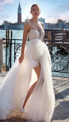 For brides who dream about a romantic, modern dress: charming tulle dress with a side slit and oversized bow on the hip. The draped tulle neckline and straps add a sophisticated, unforgettable sensuality. Nicole Milano Esmeray