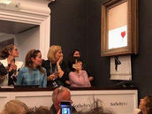 Banksy shocks art world by shredding $1.4 million work at auction