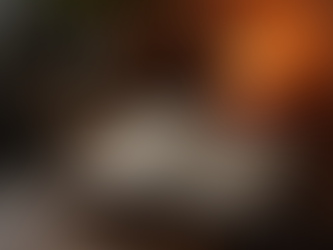 An opened Bible with a lite candle behind it.