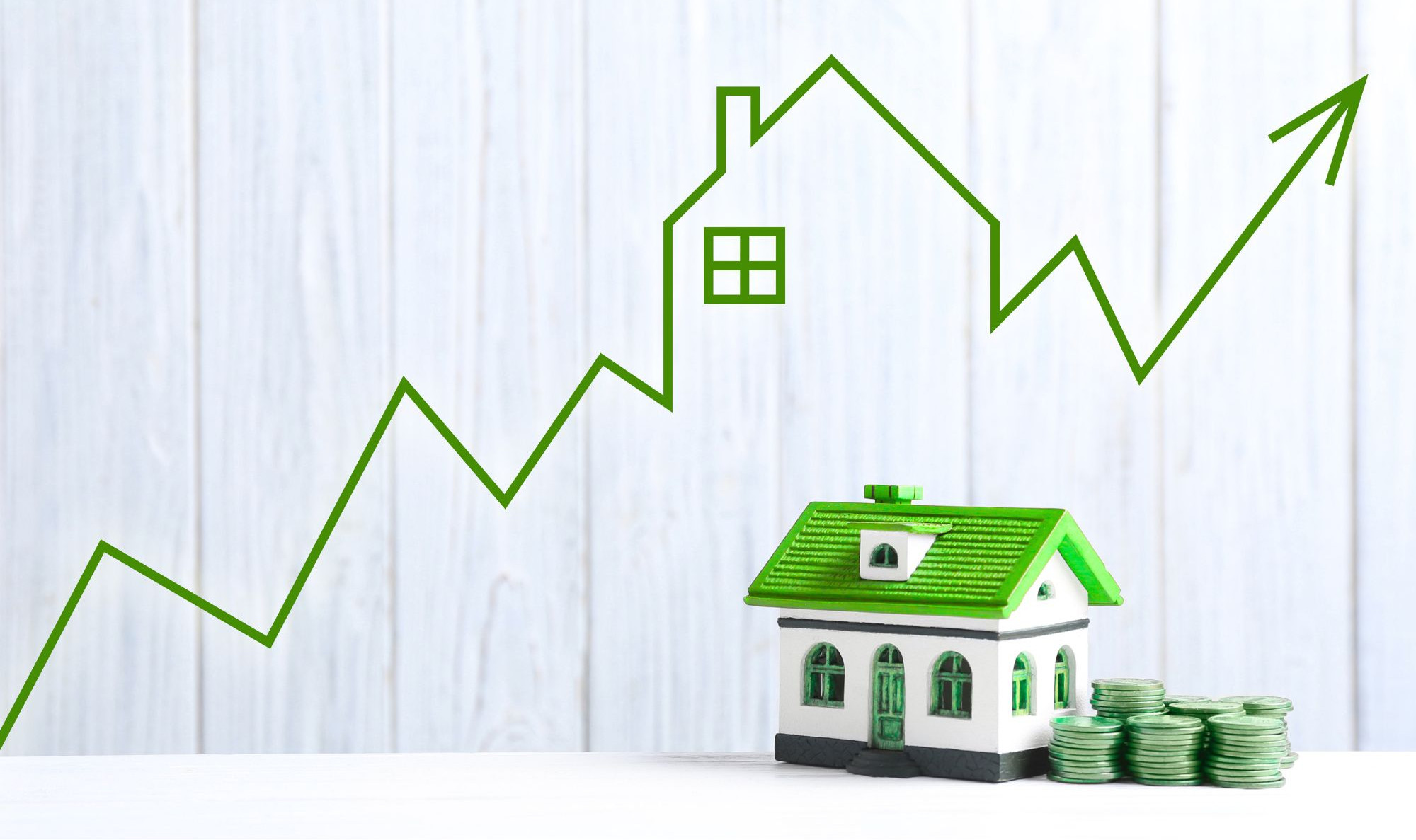 Toy house with stacks of green coins and a rising green line arrow, suggesting growing home value on a white background