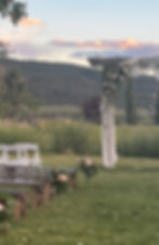Wedding arch decorated with spring pink flowers and white draping at wedding venue in Grand Junction.