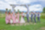 Spring Wedding outdoor ceremony site at Gunnison Wedding Venue near the Black Canyon. Bridesmaids wearing a Spring pink dresses and Groomen at wearing Gray
