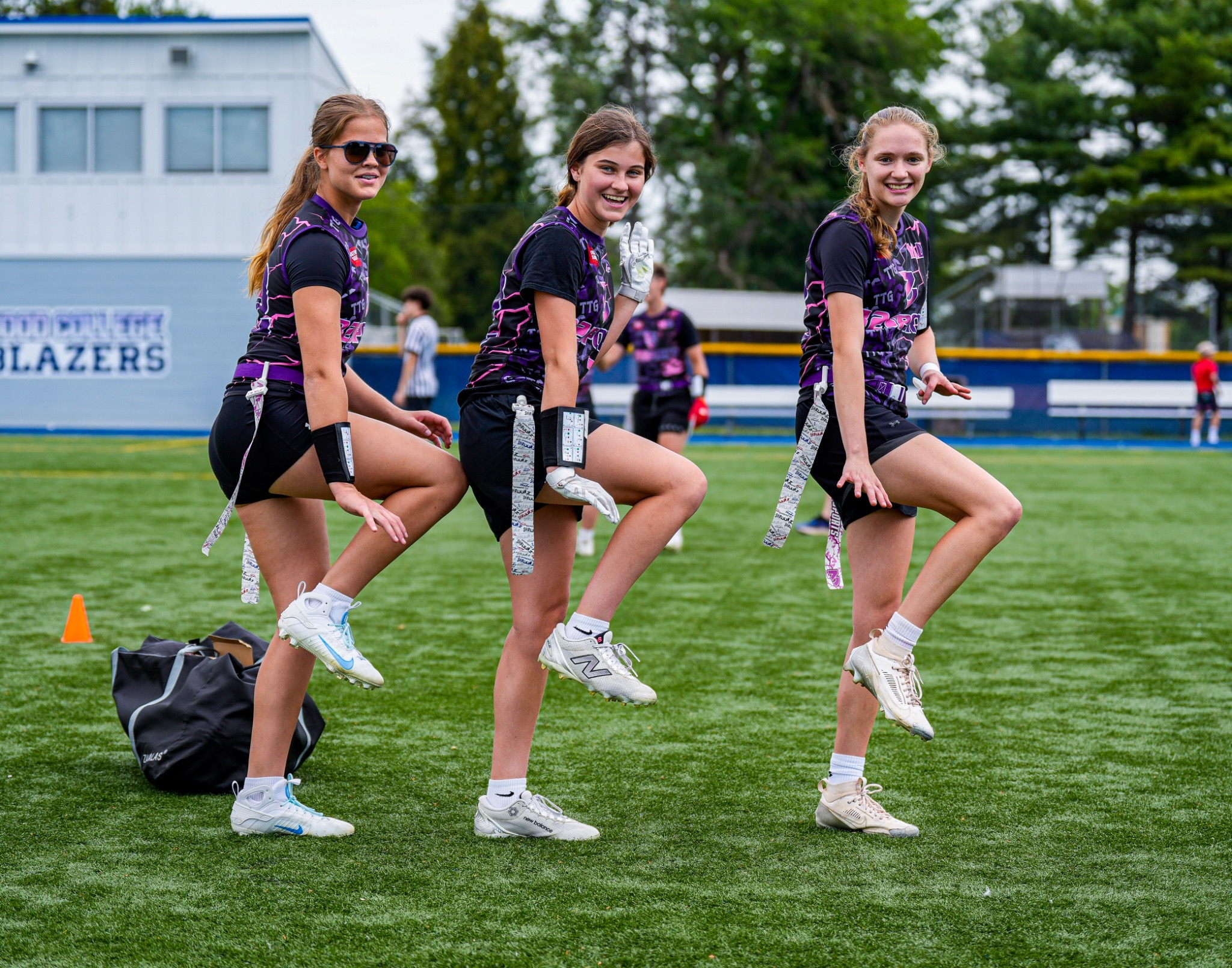Three 32 Sports flag football athletes warming up together on the field