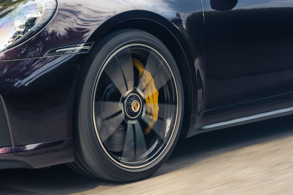 Detailaufnahme Porsche 911 Turbo S 992.1 mit gelber Keramikbremse und schwarz-silberner Felge