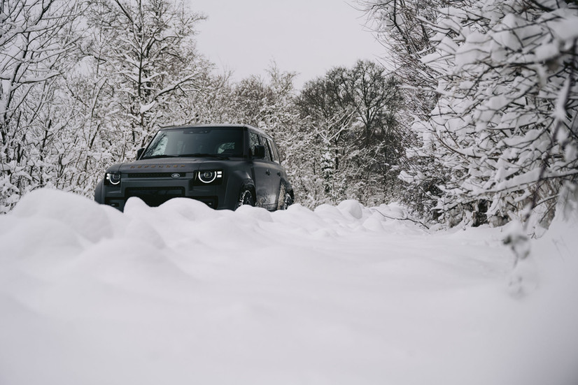 Land Rover Defender Octa 2026 in Charente Grey matt im Tiefschnee, Frontansicht aus Bodenperspektive