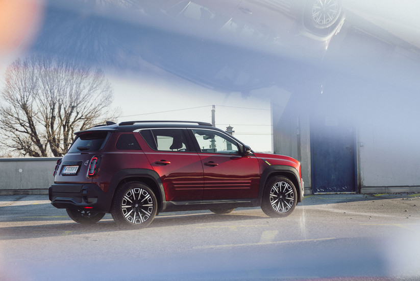 Renault 4 Elektro Iconic Heckansicht seitlich in Dunkelrot – kompaktes Elektro-SUV