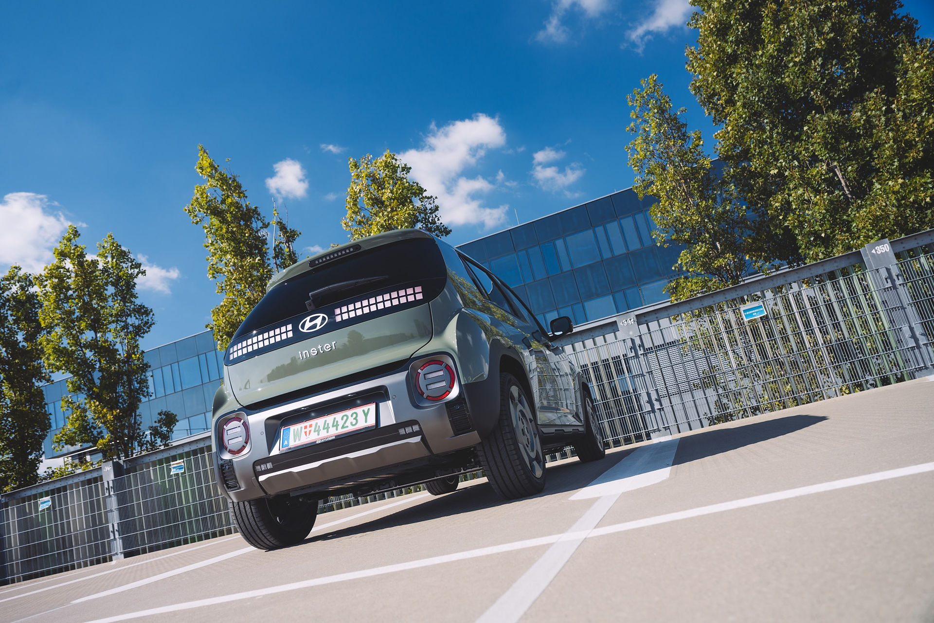 Heckansicht des Hyundai Inster Cross Line 49 kWh – charakteristische LED-Rückleuchten im Pixel-Design und moderner Elektro-Look unter blauem Himmel.