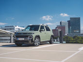Hyundai Inster Cross Line 49 kWh auf einem Parkdeck vor Wiener Skyline – urbaner Elektro-SUV mit markantem LED-Tagfahrlicht und kompaktem Format
