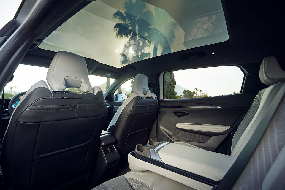 Innenaufnahme des Renault Scenic E-Tech Electric mit Solarbay-Glasdach, moderne Rücksitze mit hellem Stoffdesign – lichtdurchfluteter Innenraum