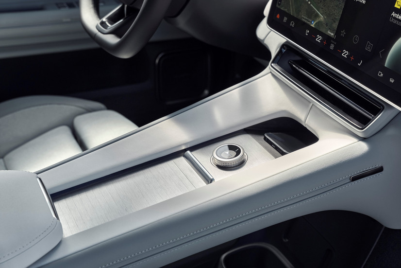 Elegante Mittelkonsole des Polestar 4 mit Aluminium-Finish, Drehregler und integriertem Smartphone-Ablagefach