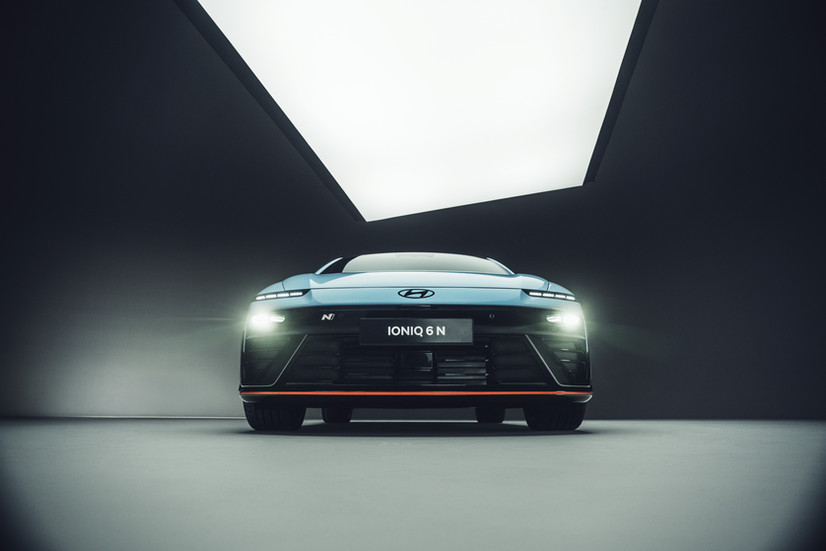 Hyundai Ioniq 6 N in direkter Frontansicht mit eingeschaltetem LED-Licht – betont breite, aerodynamisch flache Frontpartie mit markantem N-Kühlergrill und roter Designlinie