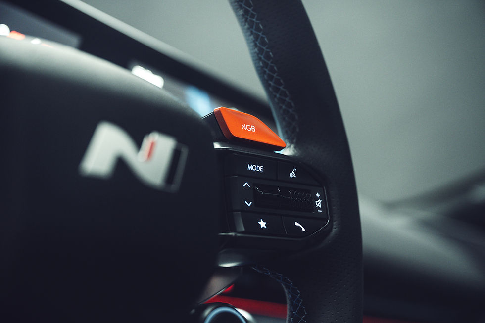 Nahaufnahme des Lenkrads im Hyundai Ioniq 6 N mit rotem NGB-Knopf – sportlicher Innenraum mit Fahrmoduswahl und markantem N-Branding
