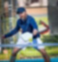 Male athlete volleys pickleball at the net.jpg