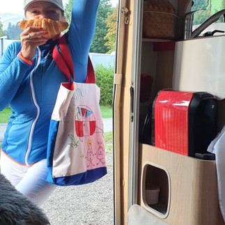 Frau mit Tasche mit einem Croissant vorm Mund