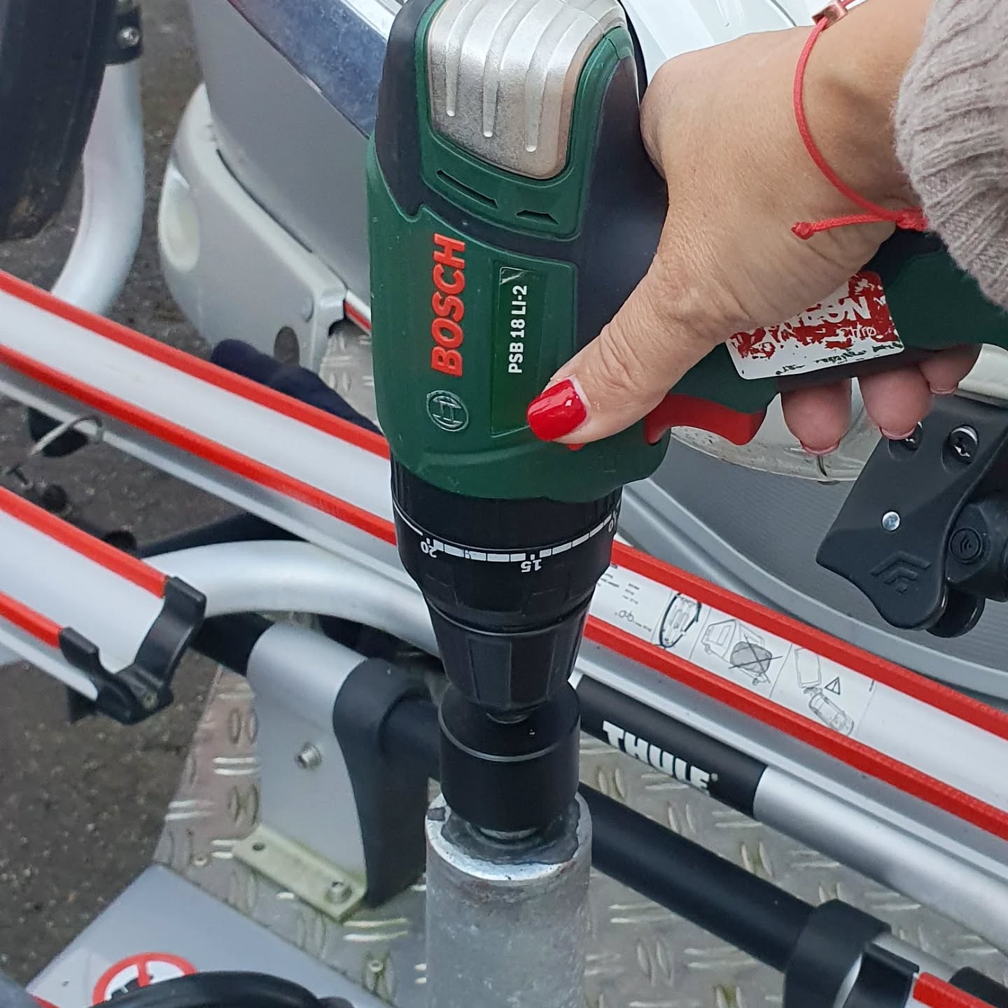FrauenHand mit Bosch Akkuschrauber dreht am Stützrad von Eriba Rockabilly