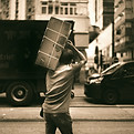 man in t-shirt and pants carrying box in