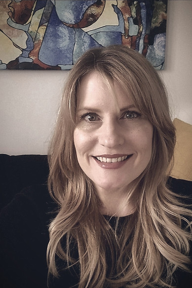 Theresa sitting on a couch with a friendly smile on her face.