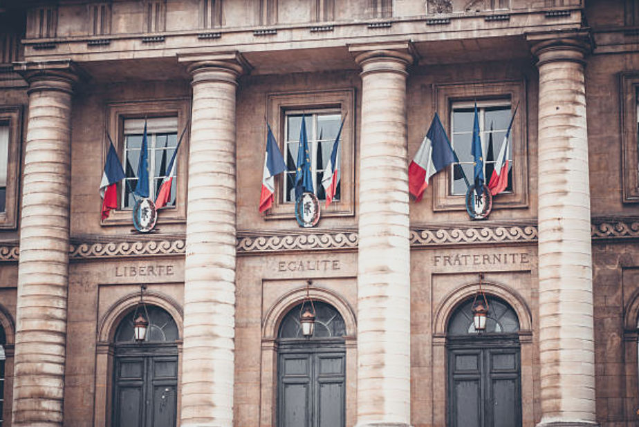 French prefecture building with flags, symbolizing the bureaucracy expats navigate when living in France