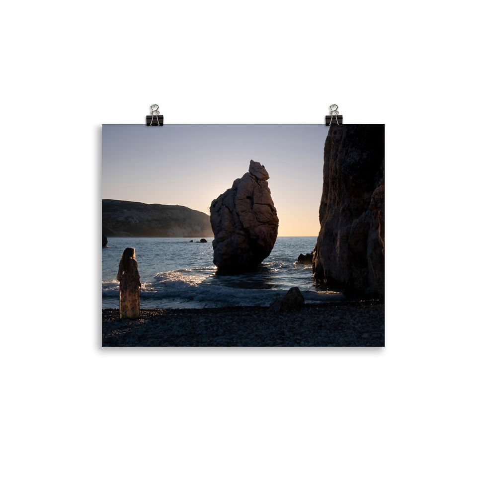 a woman gazing out at the sunrise over the water with a small sea stack rising up out of the water