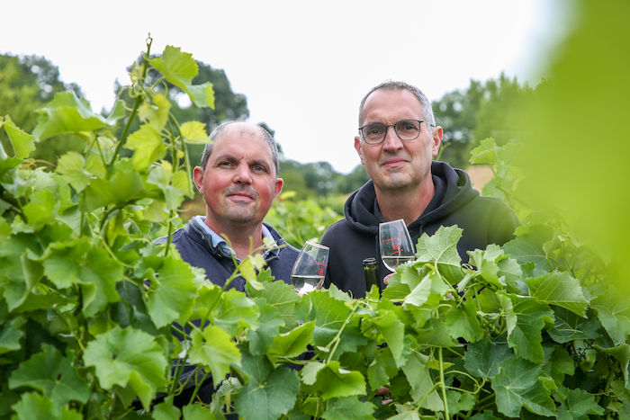 Pascal et François Denis, vignerons de la troisième génération, un verre de vin à la main au milieu des vignes du Domaine de La Garnaudière