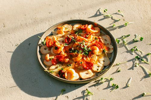 Crevettes sautées aux tomates et aux herbes dans un plat, accord mets pour le cocktail Cranberry du Domaine de La Garnaudière
