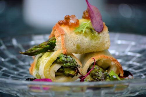 Roulés d'asperges et de légumes verts servis sur un plat en cristal, accord végétarien de La Royale du Domaine de La Garnaudière