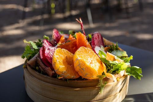 Salade colorée et croquettes de légumes dans un panier en bois, accord végétarien du cocktail Alizée bleue du Domaine de La Garnaudière
