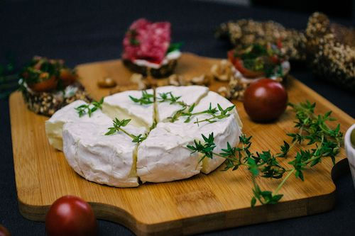 Camembert rôti aux herbes sur une planche en bois, accord fromage pour le Merlot rosé du Domaine de La Garnaudière