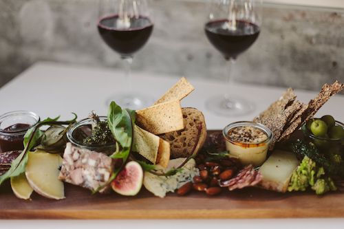 Planche de charcuterie et de fromages avec deux verres de vin, accord mets et vins pour le Grolleau rosé du Domaine de La Garnaudière