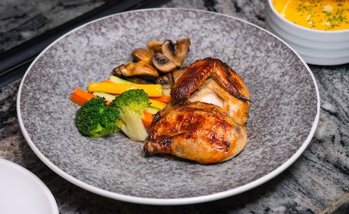 Poulet rôti aux légumes et champignons sur une assiette grise, accord mets et vins pour le Souvignier gris du Domaine de La Garnaudière