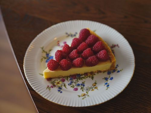 Part de tarte aux framboises sur une assiette fleurie, accord dessert du cocktail Cranberry du Domaine de La Garnaudière