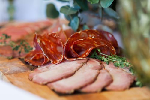 Charcuterie et viande séchée en tranches sur une planche aux herbes, accord mets et vins pour le Monarch rosé du Domaine de La Garnaudière