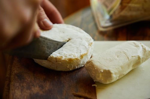 Fromage à pâte molle tranché sur une planche en bois, accord fromage de La Royale du Domaine de La Garnaudière