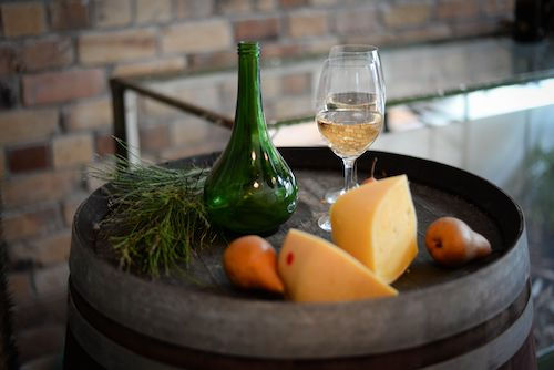Fromages sur un tonneau avec un verre de vin blanc, accord fromage du Pinot gris du Domaine de La Garnaudière