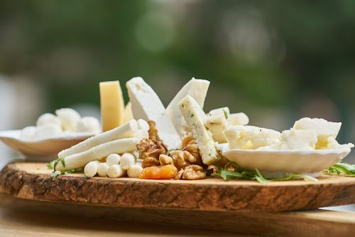 Plateau de fromages et de noix sur une planche en bois, accord fromage du Grolleau rosé du Domaine de La Garnaudière