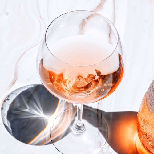 Verre de vin rosé posé sur une table au soleil, vin rosé du Domaine de La Garnaudière