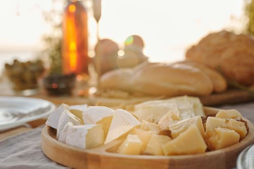 Plateau de fromages et pain sur une planche ronde, accord fromage du Monarch rosé du Domaine de La Garnaudière