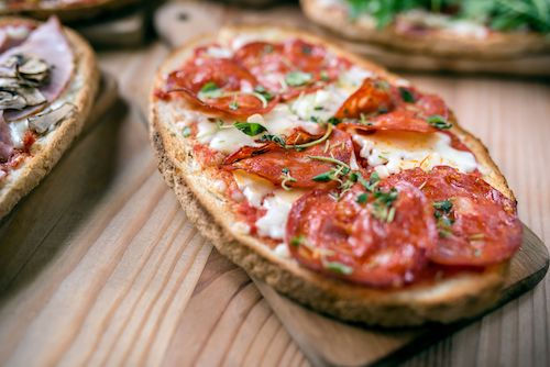 Tartine de tomates et de mozzarella à l'origan sur une planche en bois, accord mets pour le cocktail Sangria du Domaine de La Garnaudière