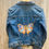 Thumbnail: Colorful butterfly hand painted on back panel of jean jacket 