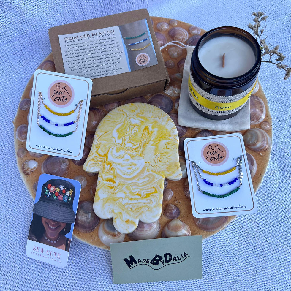 A fundraiser box including the 3-bracelet set, a hanging wall decor hamsa, and a soy-wax candle set. Fundraiser box for raising money for the hostages of 7 October