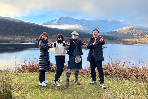 Guests and their Highland guide overlooking Loch Cluanie and snow-covered mountains