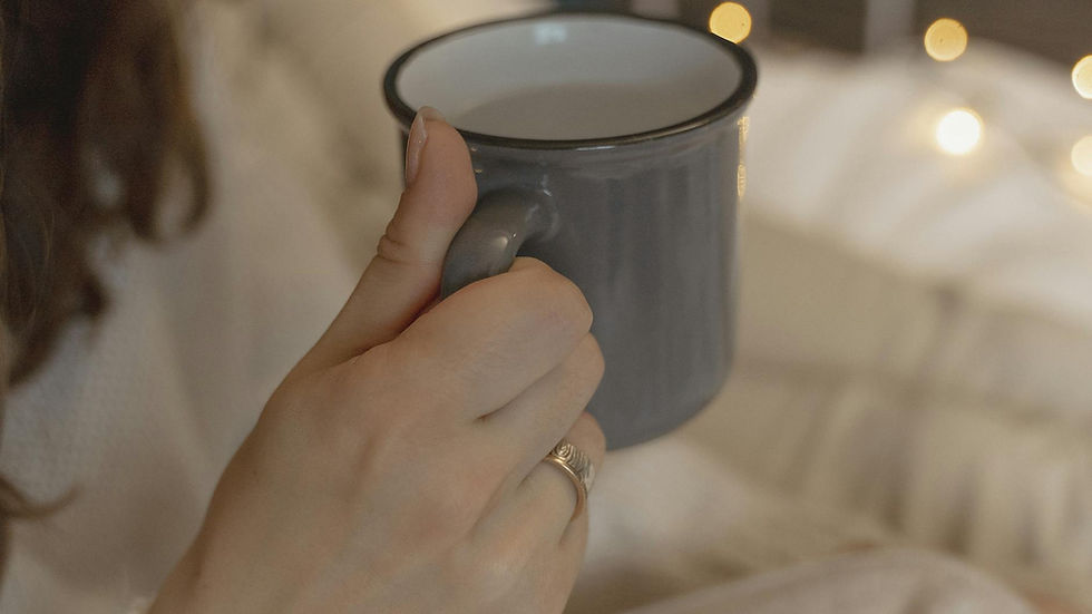 Soft focus on a hand holding a warm mug, capturing a cozy and serene atmosphere.