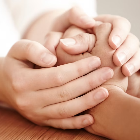 two sets of hands hold each other in prayer