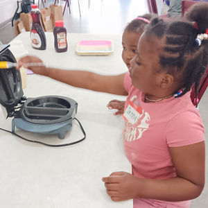 young girl holds paint brush prepared to paint