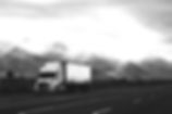 A truck with new tires driving through a mountain landscape