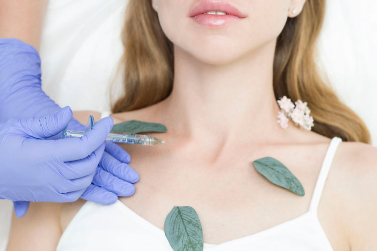 The cosmetologist makes anti-aging injections against wrinkles on the neck and decollete a