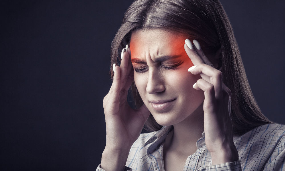 Praxis für Neurologie und Kopfschmerzen junge Frau hat Migräne Kopfschmerzen und fasst sich an den Kopf